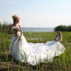 Blumenmaedchen haelt die schleppe der gluecklichen Braut am Achterwasser
