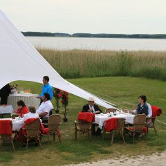 Inselhof Vineta Gaeste sitzen auf der Festwiese