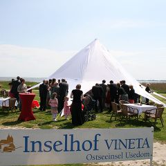 Das grosse Schild Inselhof Vineta und im Hintergrund die Hochzeitsgesellschaft