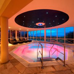 Wellness Whirlpool im Inselhof Vineta am Abend beleuchtet und Liegen im Hintergrund