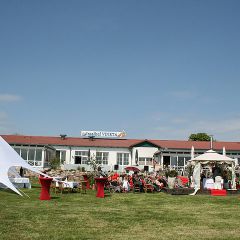 Festwiese des Inselhof Vineta und im Hintergrund ist die Gastronomie-Terrasse zu sehen