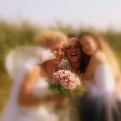 Braut mit Freundin und Blumenmaedchen laecheln
