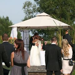 Inselhof Vineta das Paar kuesst sich unter dem Hochzeitspavillon