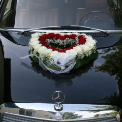 Schwarzer Mercedes mit Rosenarrangement in Herzform auf der Motorhaube